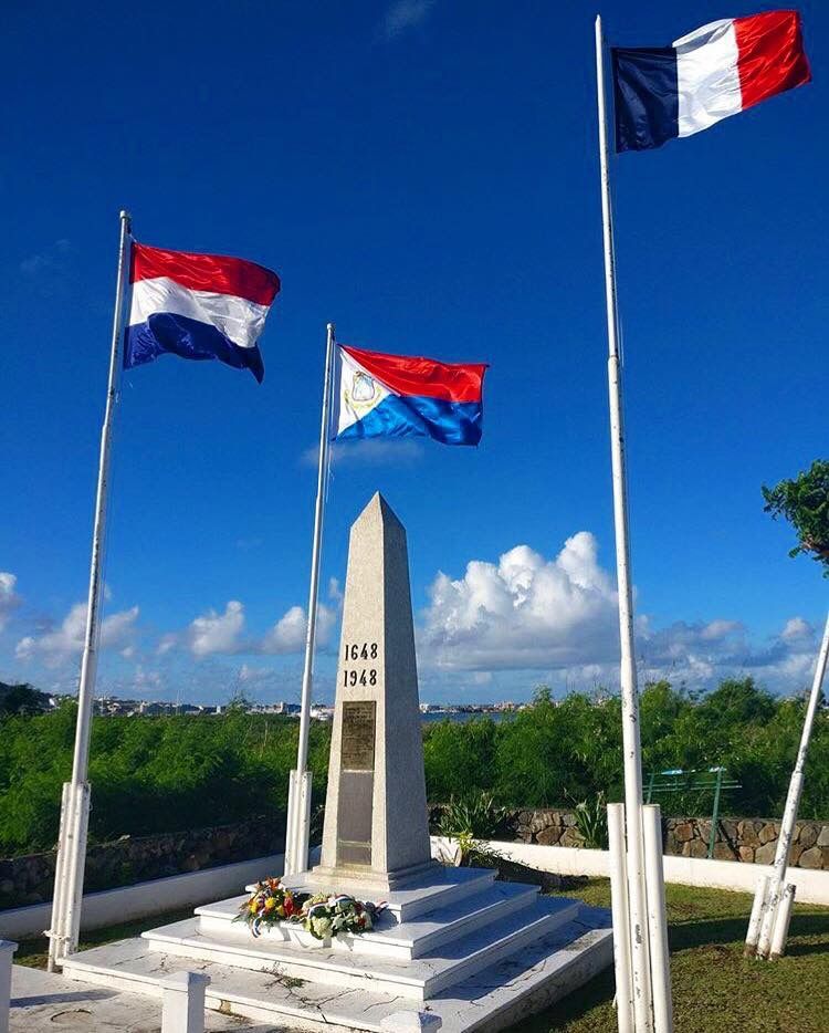 Border monument with Dutch, Sint Maarten and French flags marking the 1648 treaty