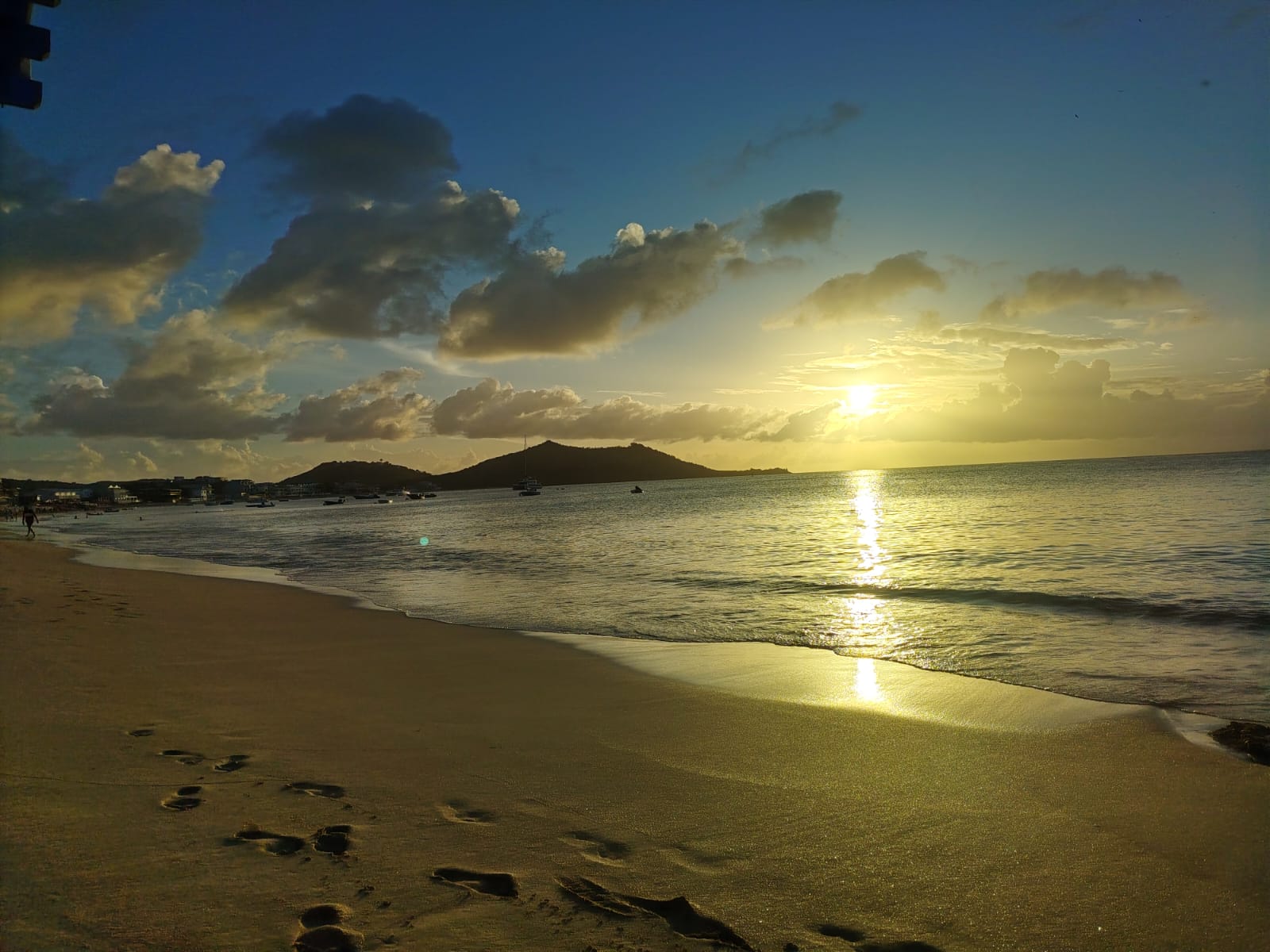 Sunset over a quiet Sint Maarten beach with golden light on the sand