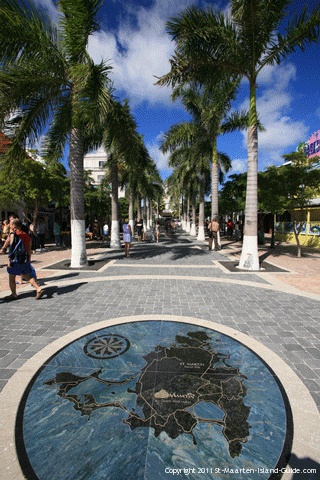 Island map set into the walkway on a palm lined street in Philipsburg